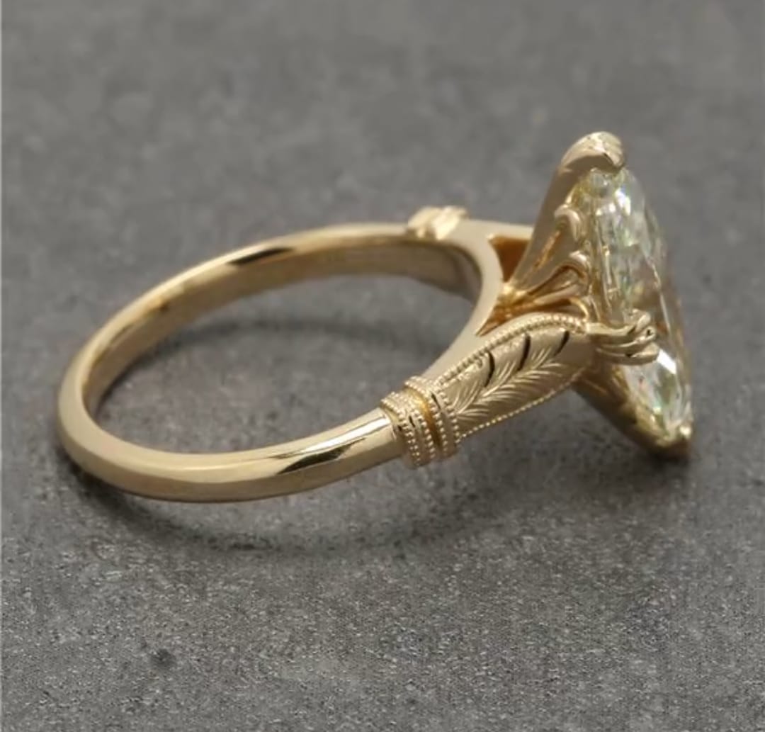 Detailed shot of the milgrain band and clear marquise diamond facet structure.