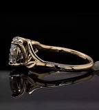 Side view showing leaf detail and basket setting of a 3 CT round lab diamond ring in yellow gold.