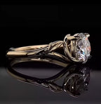 Side profile shot of a 3 carat round brilliant lab grown diamond with sculpted leaf band.