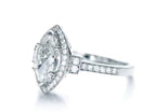 Angled view showcasing the elongated 3 CT marquise lab diamond with milgrain halo setting.