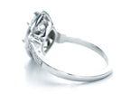 High-angle side view highlighting the intricate scroll filigree under-gallery on white gold band.
