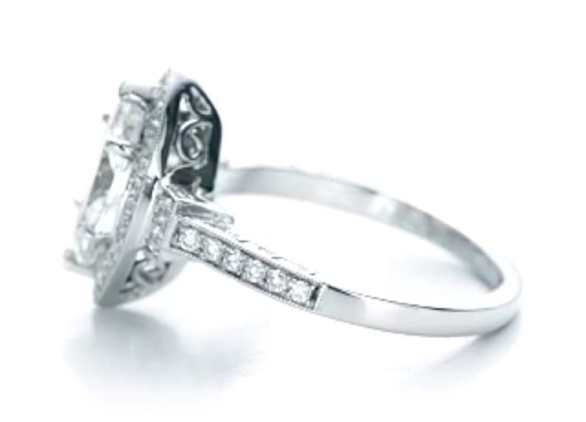 Side angle view highlighting the milgrain detailing, halo structure, and filigree setting.