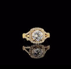 Direct top view of a 2 carat round brilliant lab grown diamond ring with cushion halo on black background.