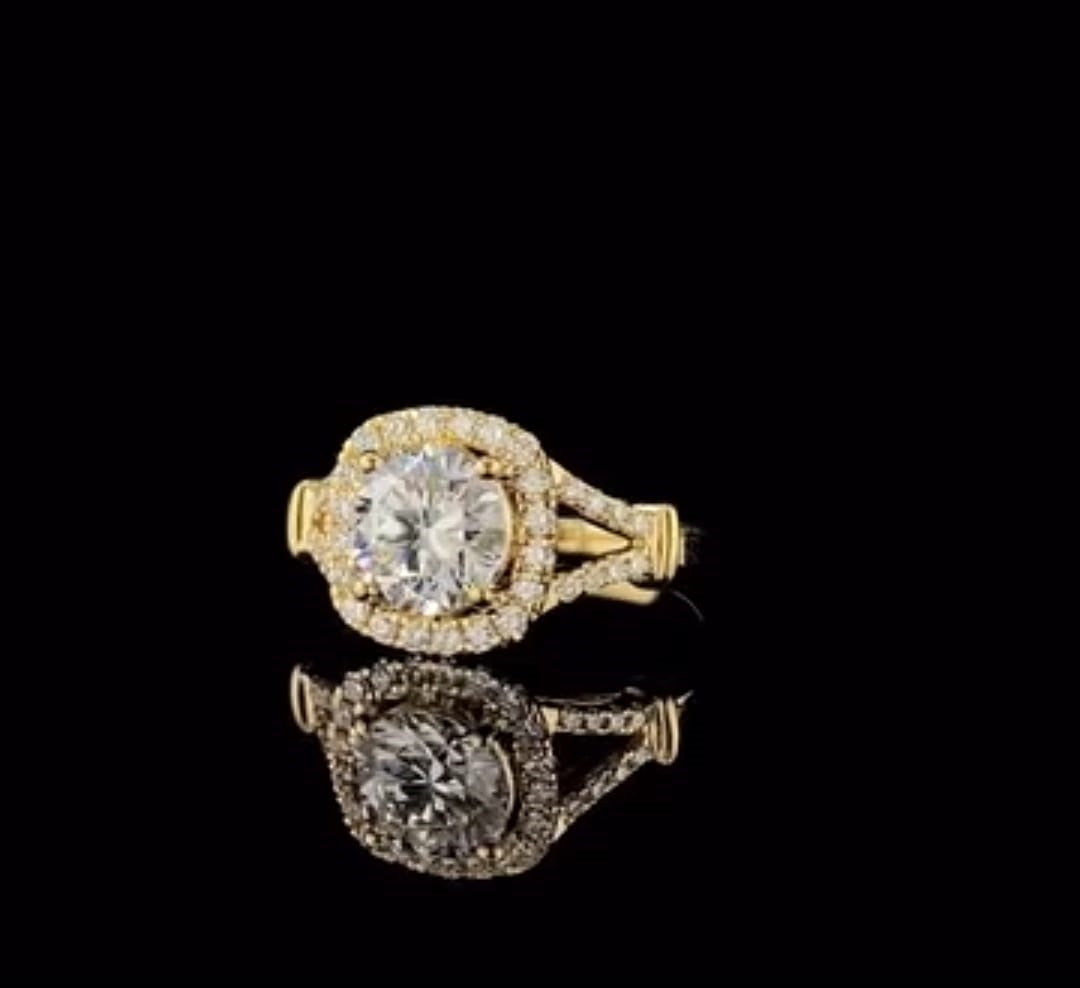 High-angle perspective view of yellow gold cushion halo ring with pave-set split shank.