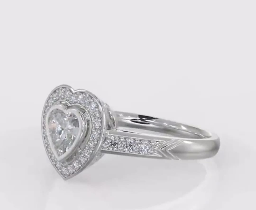 Side angle view showing the heart bezel halo, pave shank, and chevron details on a white gold ring.