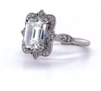 Angled view showcasing a 3 CT emerald cut lab grown diamond ring with scalloped milgrain halo.