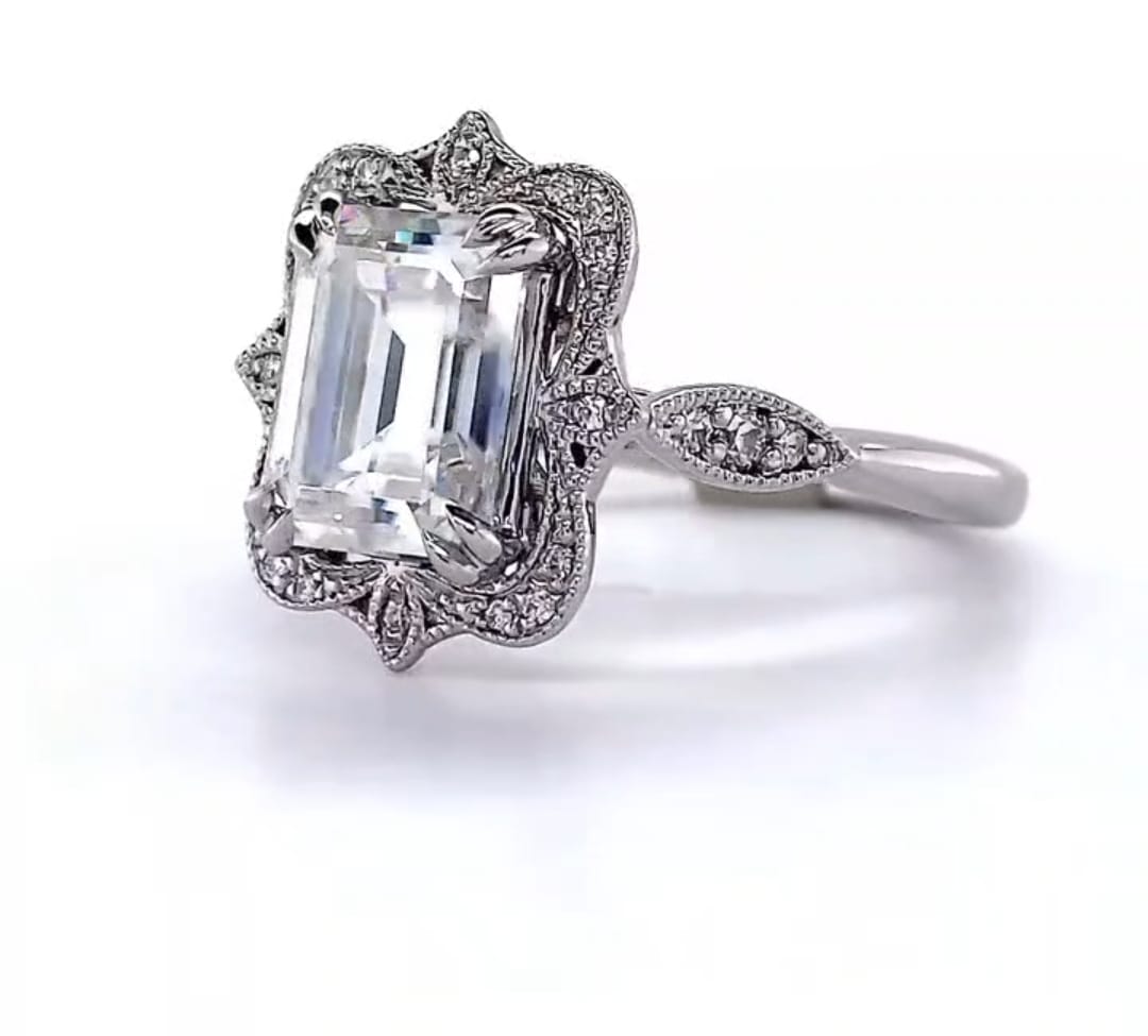 Angled view showcasing a 3 CT emerald cut lab grown diamond ring with scalloped milgrain halo.