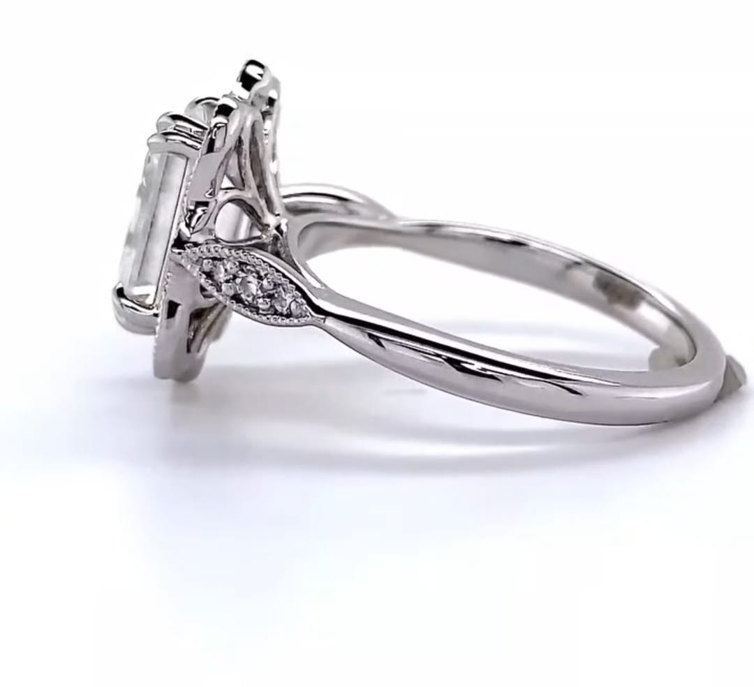Side profile view showing the basket elevation, leaf shoulder accents, and polished shank of white gold ring.