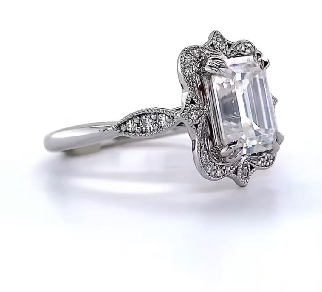 Side perspective highlighting the scalloped milgrain halo edge and double claw prongs on 3 CT emerald ring.