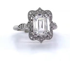 Front view of emerald cut lab diamond engagement ring with ornate scalloped frame and leaf accents.
