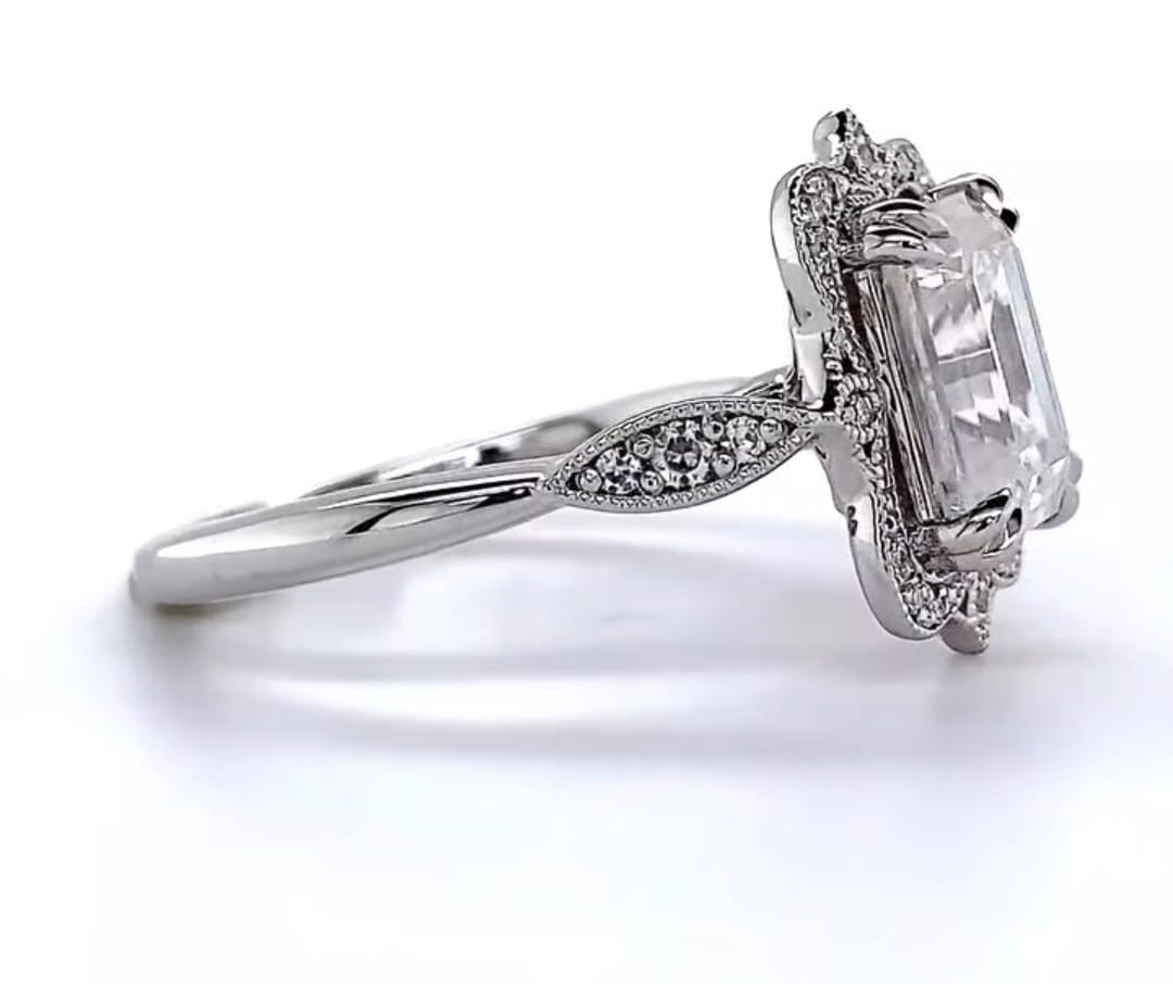 Close-up profile view highlighting the milgrain leaf shoulder design and step-cut diamond facets.