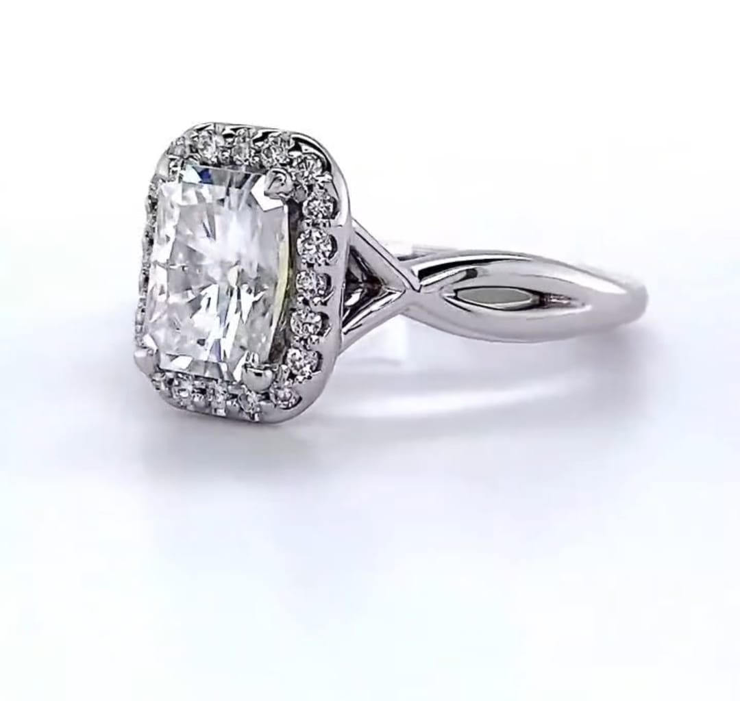 Angled front view of a 2 CT radiant cut lab grown diamond engagement ring with halo and twisted band.