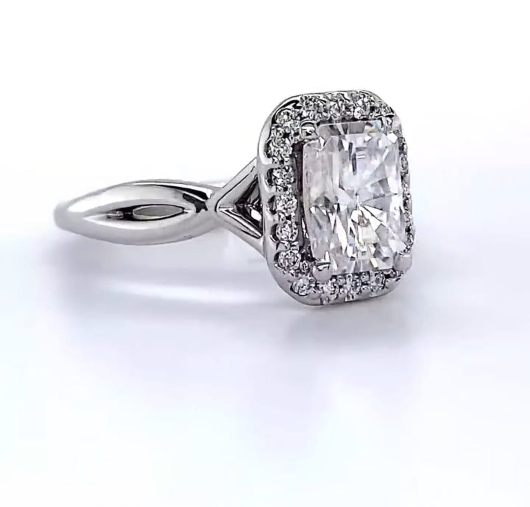 Opposite angle view displaying the brilliant facets of the 2 CT radiant center stone and pavé halo.