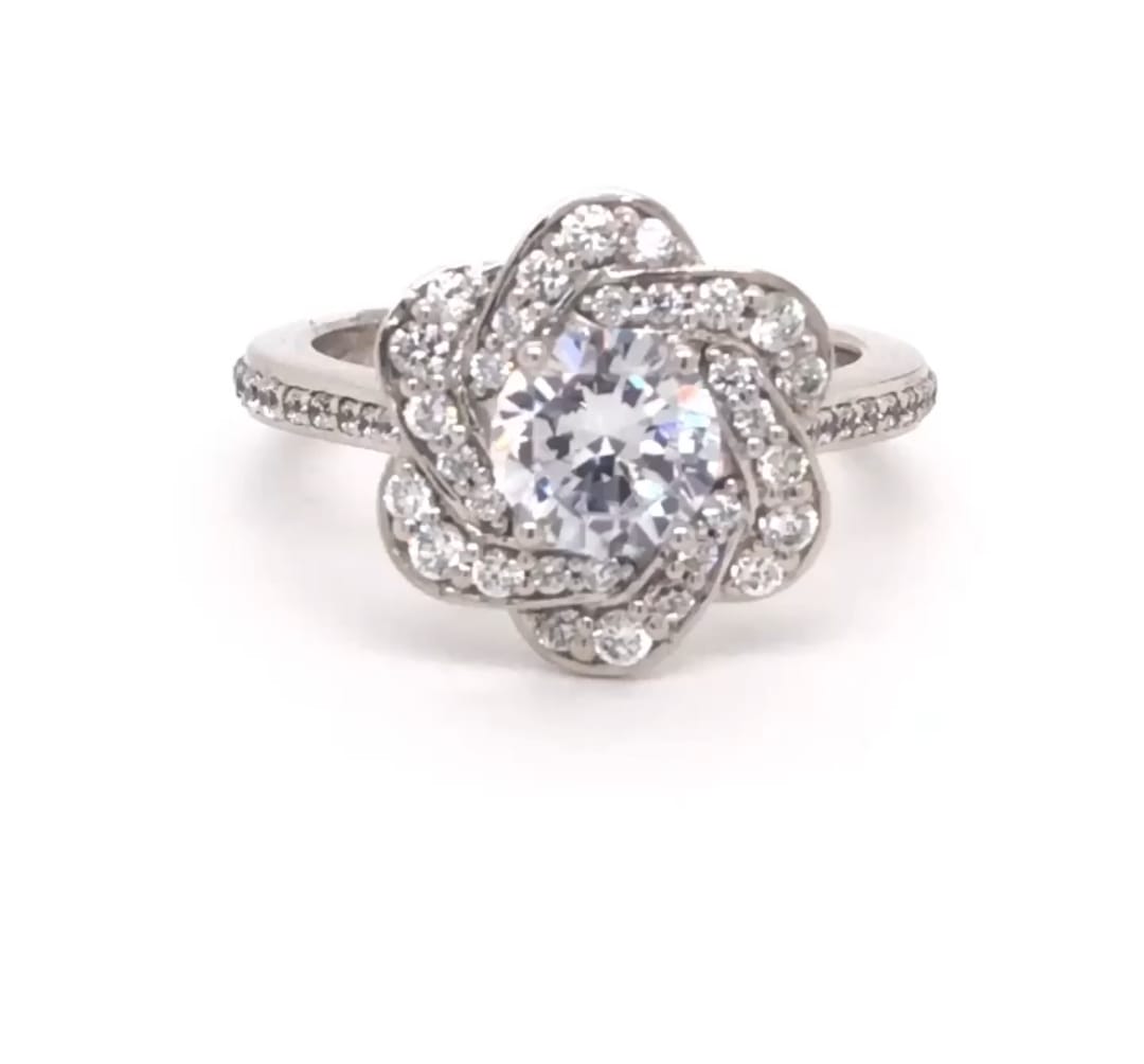 Front view of 2 CT round cut lab grown diamond engagement ring with floral swirl halo and white metal band.