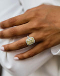 On-hand view of a 2 CT radiant cut fancy yellow lab grown diamond ring with two-tone double halo and pave split shank.