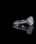 Side profile view of a 4 CT cushion cut lab grown diamond ring with a pave diamond band on a black reflective background.