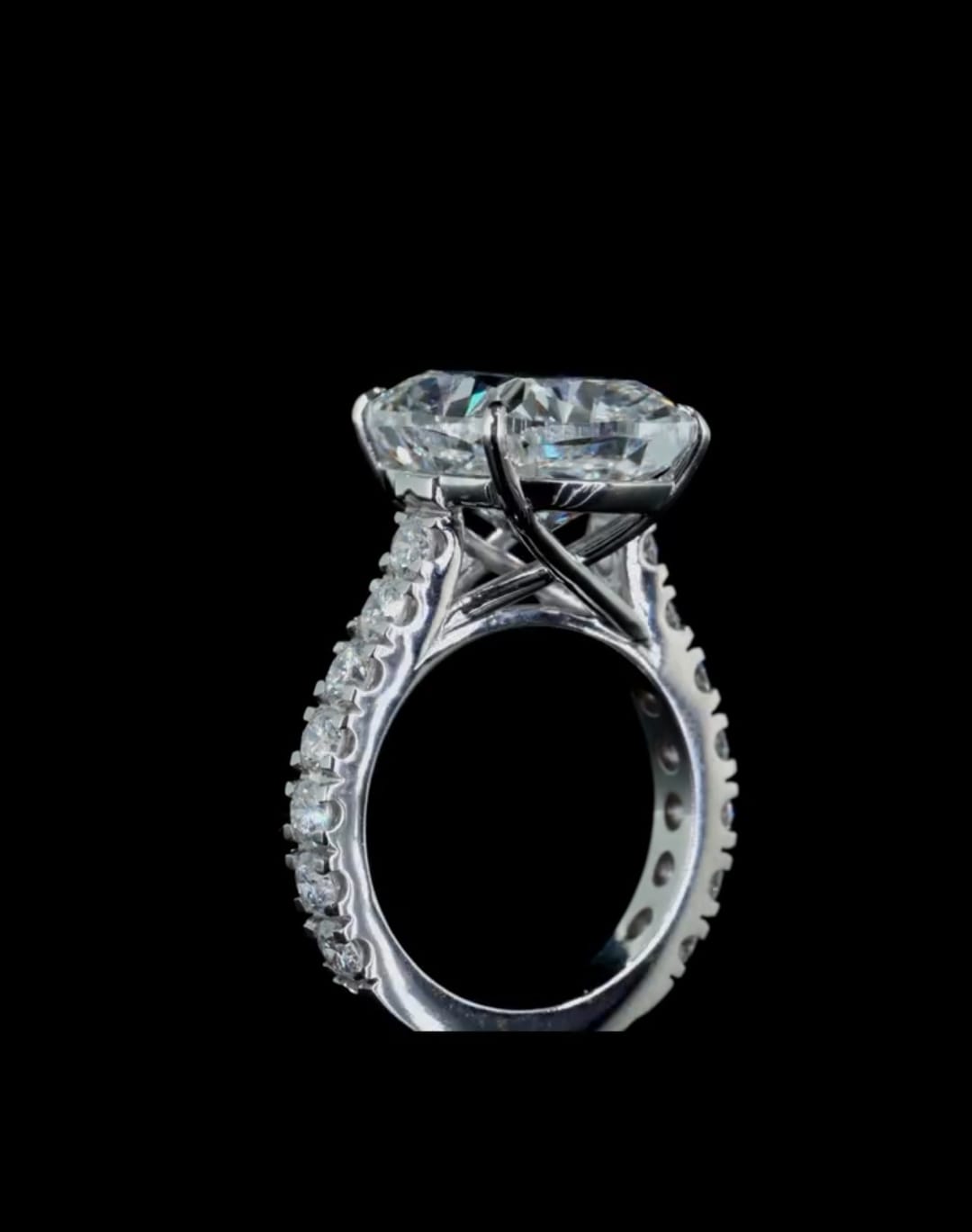 High-angle side view showcasing the cathedral setting and crisscross under-gallery prongs of a 4 carat cushion lab diamond ring.
