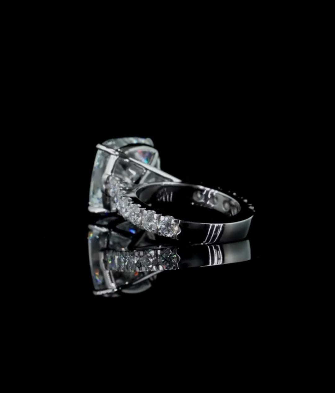 Perspective close-up of a 4 carat cushion cut lab grown diamond ring displaying the round paved diamond band.