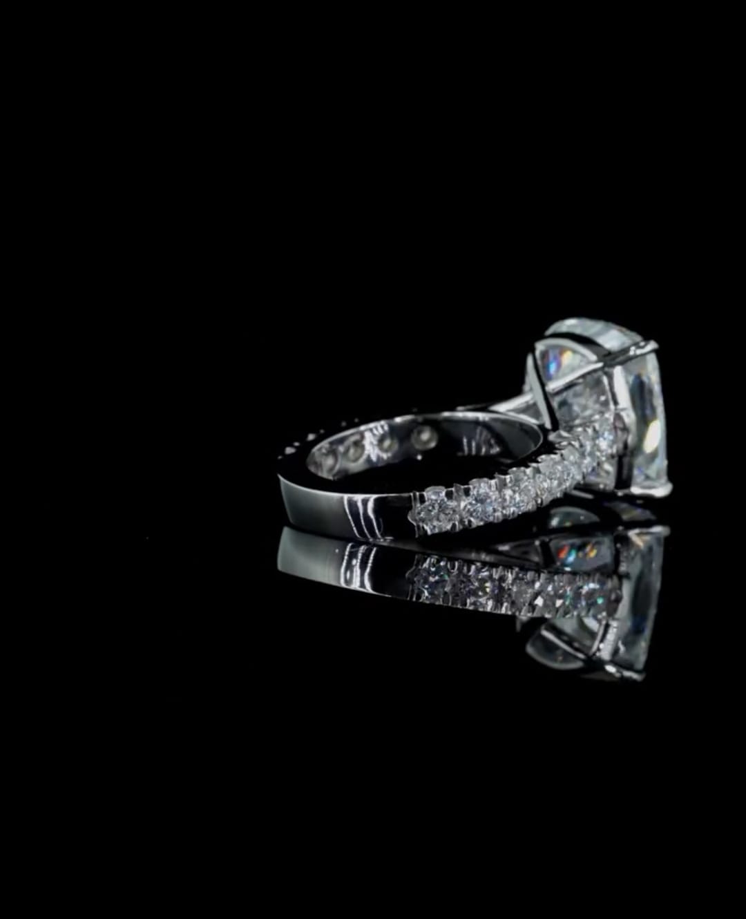 Angled shot showing the structural cathedral setting and pave-set band of a 4 CT cushion lab diamond engagement ring.