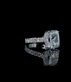 Angled portrait view of a 4 carat cushion cut lab created diamond ring showing the high brilliance and main center facet structure.