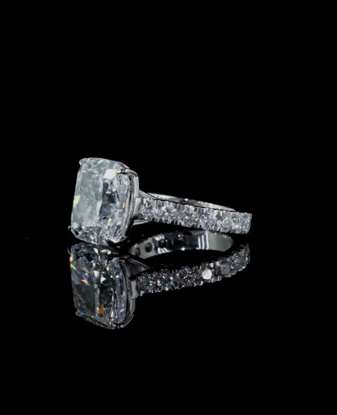 Side profile view emphasizing the large 4 CT cushion cut diamond stone height and paved diamond band on a black background.