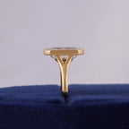 Direct side-profile view displaying the low-profile bezel setting and split cathedral shank on blue velvet.