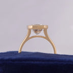 Arch profile view showing the yellow gold band and open under-gallery structure of a 3 carat emerald lab diamond bezel ring.