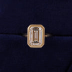 Top-down view highlighting step-cut facets of a 3 CT emerald lab diamond inside a solid gold full bezel frame.
