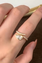 On-finger view displaying the 1.5 carat pear lab diamond in a full bezel setting on a yellow gold pavé wrap band.