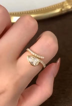 Hand view showing the unique asymmetrical bypass design and pavé diamond-accented band of the 1.5 CT pear lab diamond ring.