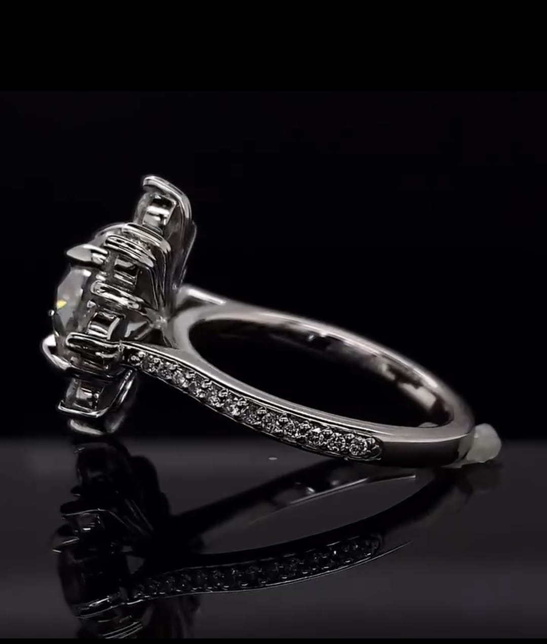 Side profile view of a 3 carat round lab grown diamond ring showing the basket setting and pavé band