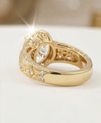 Front view of an oval cut diamond engagement ring in a secure yellow gold bezel setting with a botanical engraved band