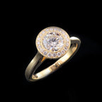 Angled shot showing a 2 ct round lab grown diamond ring with milgrain bezel halo on a black background