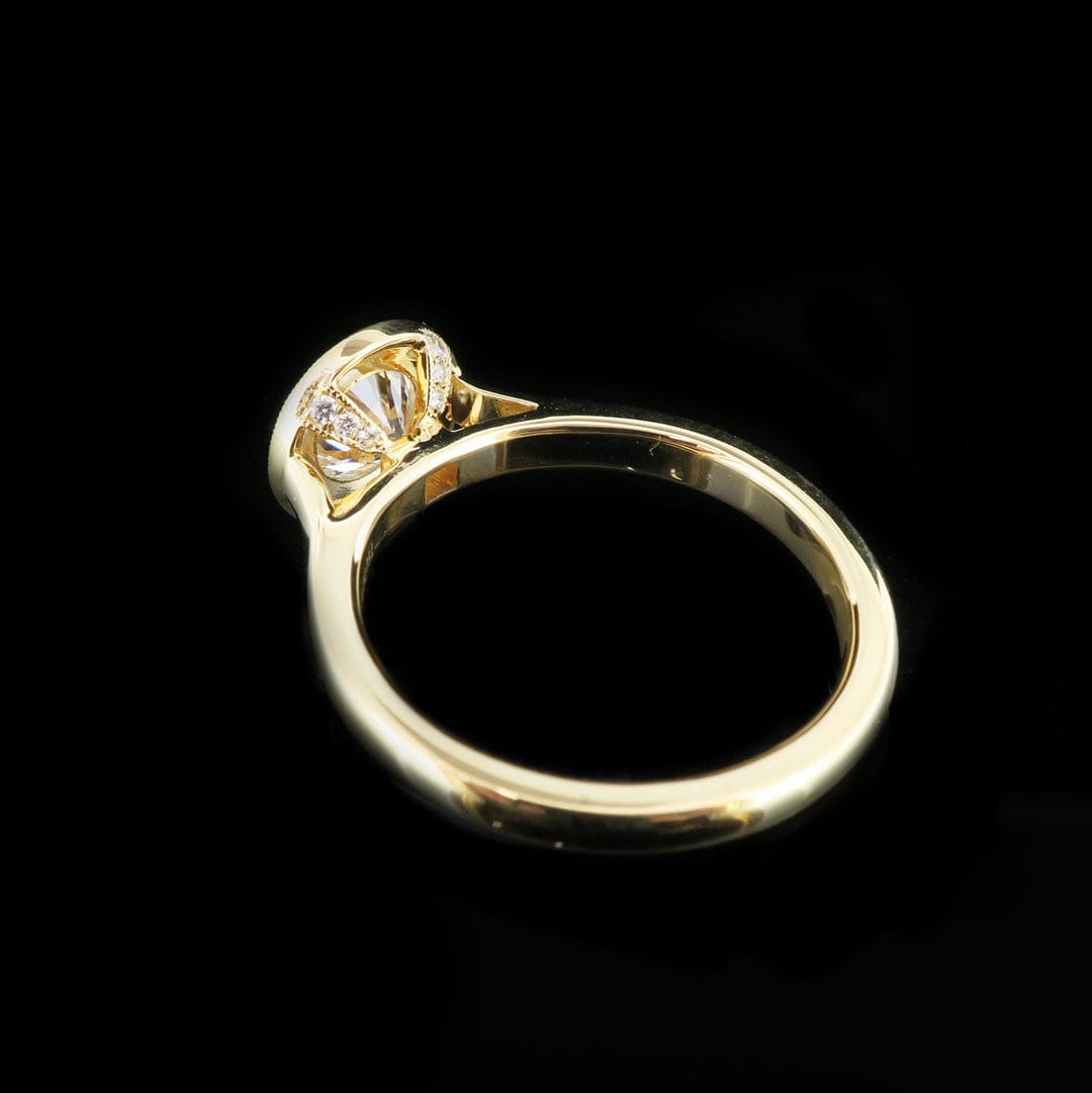 Side profile view of a 2ct round lab diamond engagement ring showing the detailed basket and polished band