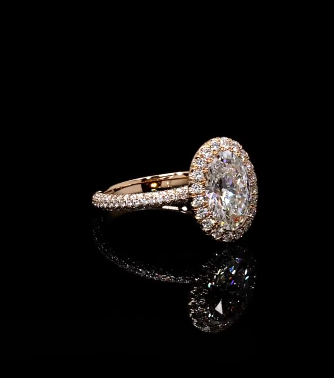 Angled view showcasing the oval center stone, halo, and shimmering pavé diamond band