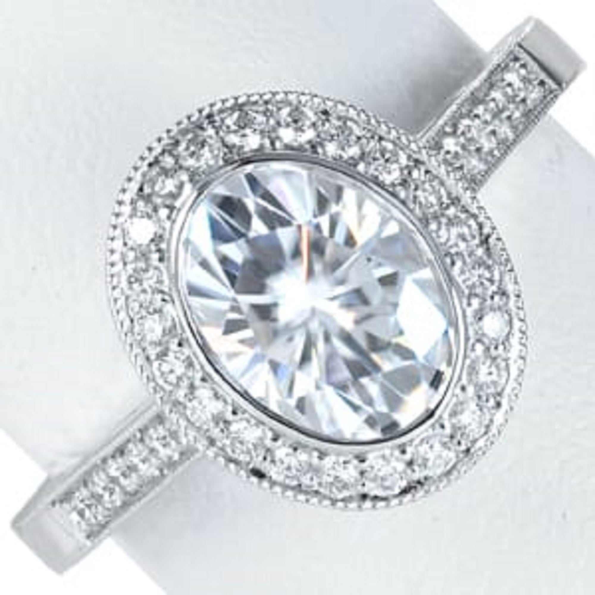 Top view of 3 carat oval lab grown diamond ring with milgrain bezel halo and pave band