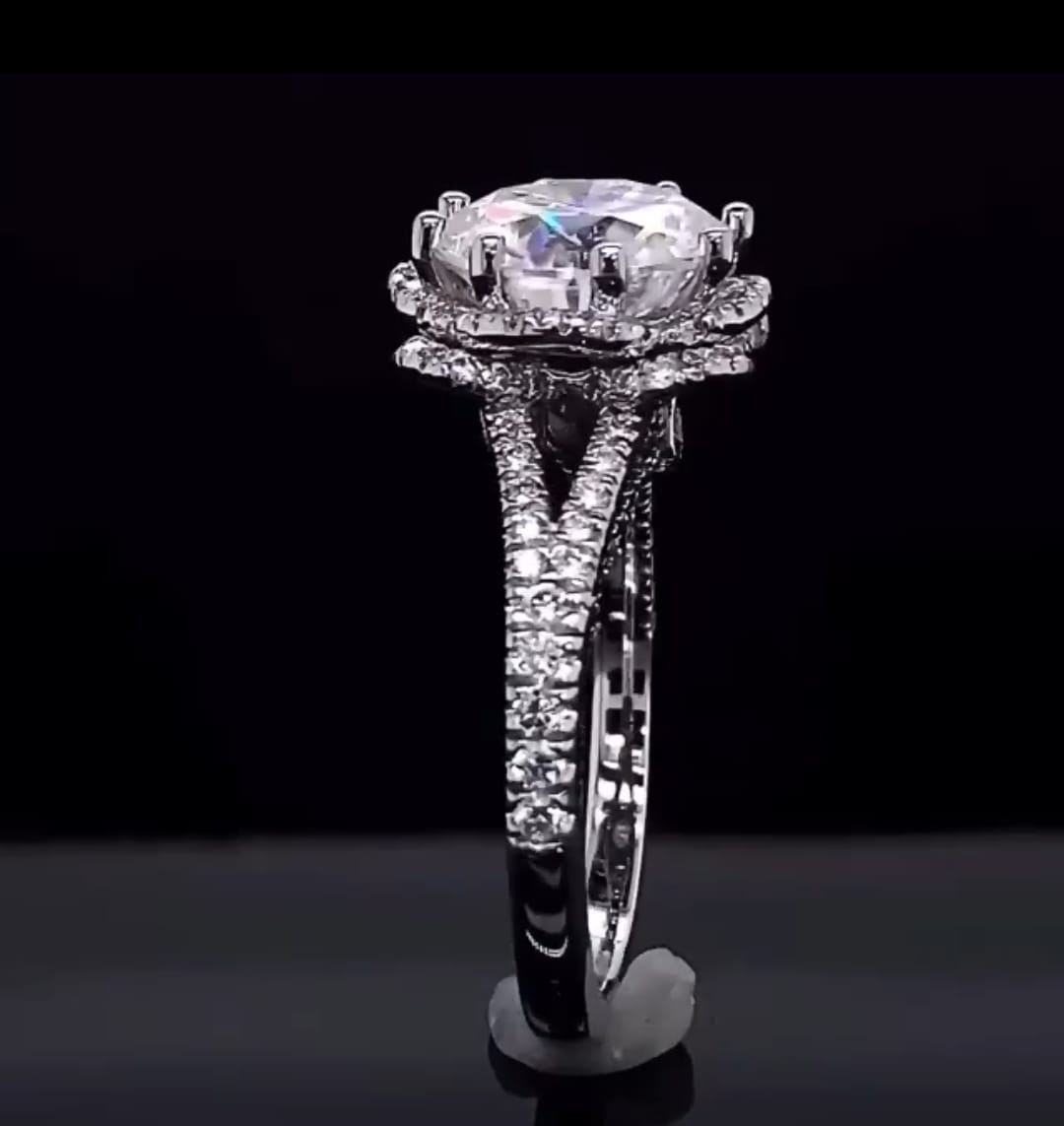 Profile view of split cathedral shank and double-tier scalloped halo structure on white gold band