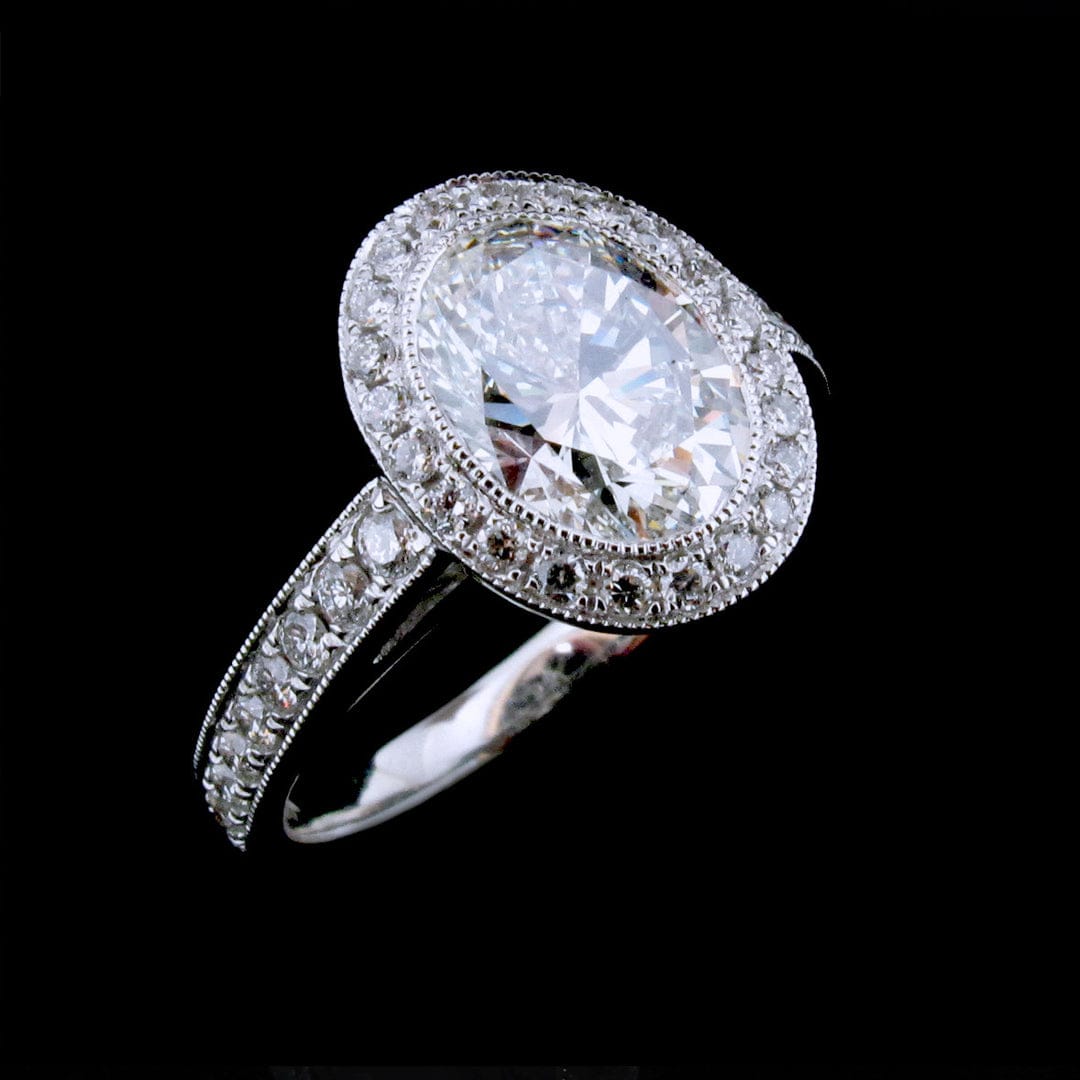 Three-quarter view of 3 carat oval lab grown diamond ring with milgrain pave halo and band