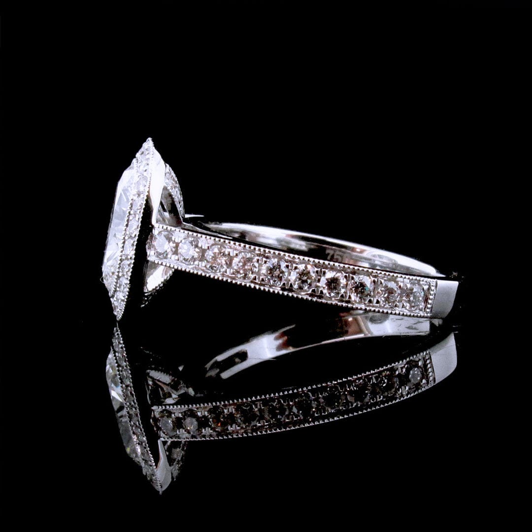 Side profile view showing pave diamond band with milgrain border and 750 gold stamp