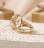 Side profile of a vintage gold engagement ring showing intricate scrollwork engraving along the tapered band