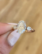 Front view of 3 CT oval lab diamond three stone engagement ring with pear accent diamonds