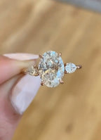 Macro detail view of 3 carat oval lab grown diamond and pear side stones in rose gold setting
