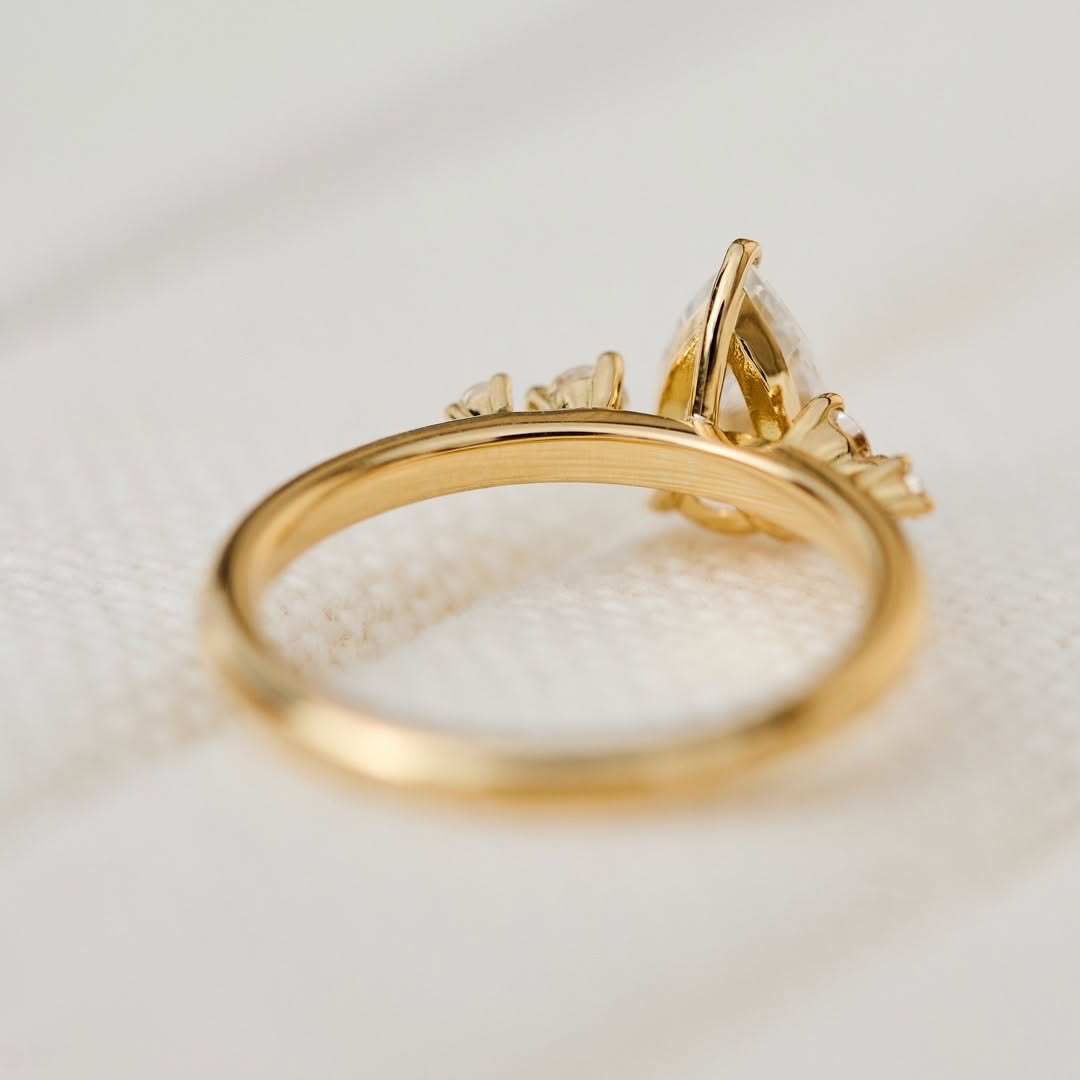 Underside and profile view of the basket setting on a yellow gold pear cut lab diamond engagement ring.
