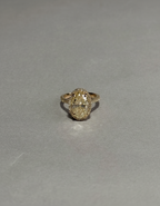 Close-up top view of a 3 CT fancy yellow oval lab-grown diamond ring with a pavé halo held by fingers.