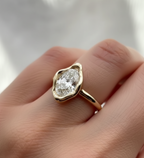 3 carat oval lab diamond engagement ring with sculpted organic bezel setting worn on a finger.