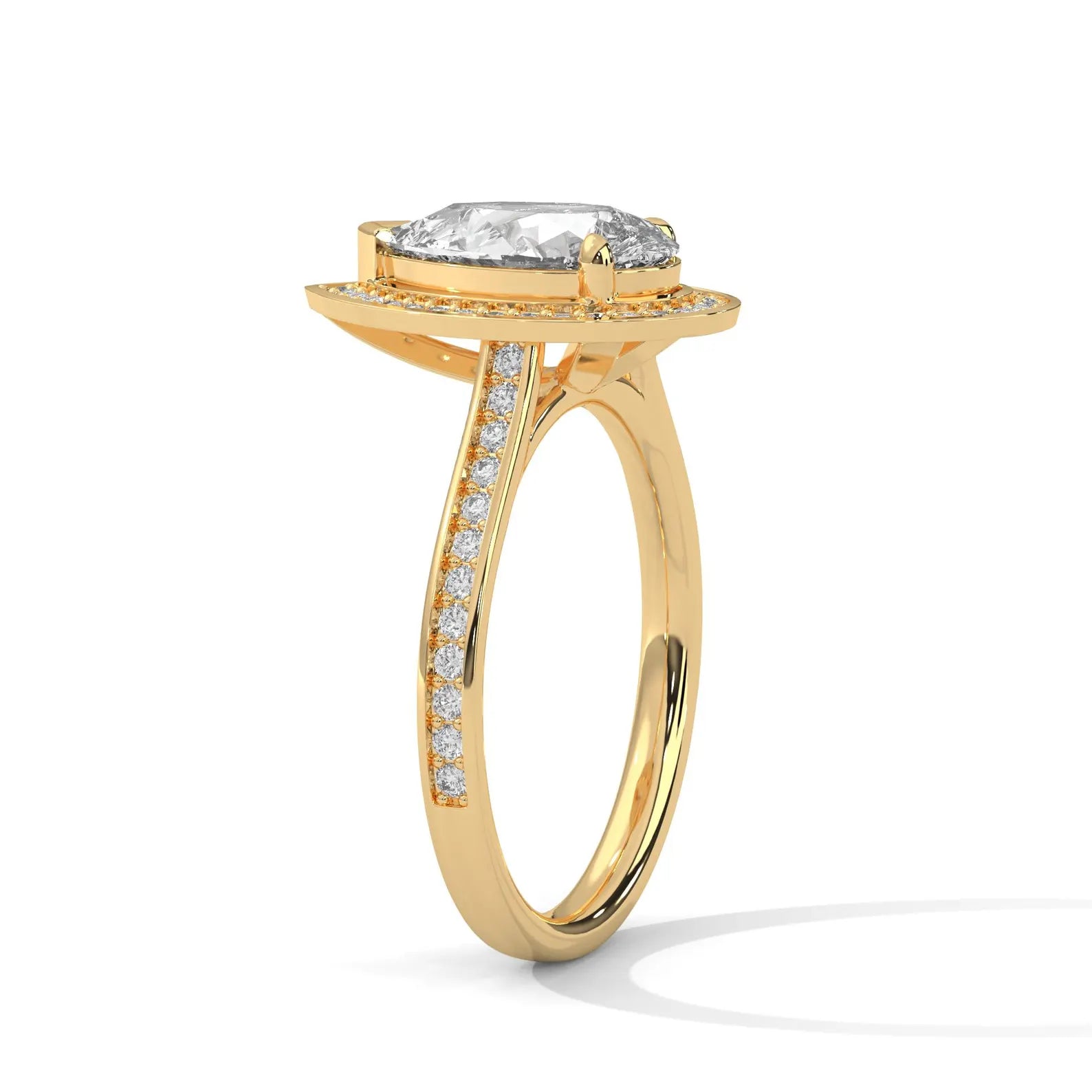 Side angle view of a 3 ct pear cut lab grown diamond halo ring in yellow gold with pave diamonds