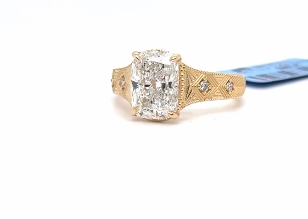 Perspective view highlighting the brilliance of a 3 CT elongated cushion cut lab diamond set on an intricately engraved gold ring