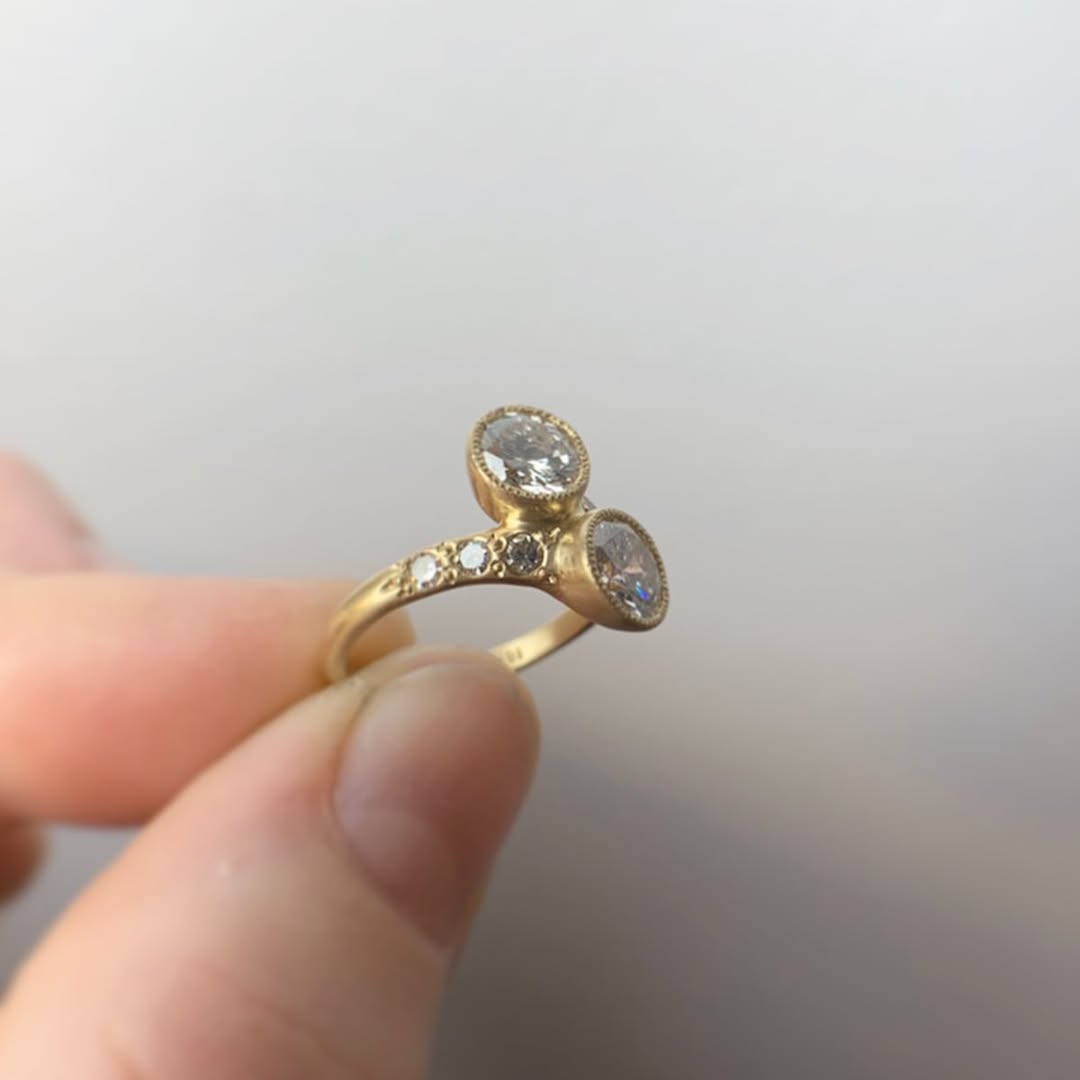 Side profile view of a yellow gold Toi et Moi lab diamond ring highlighting graduated accent diamonds along the bypass band