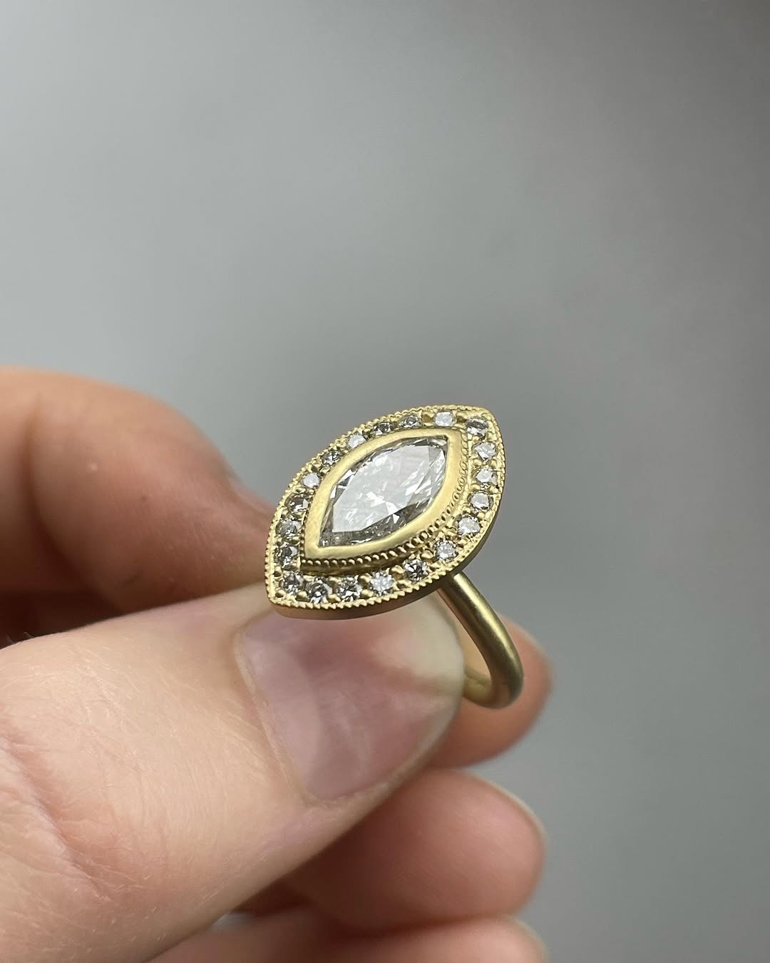 Top view of a 3 carat marquise lab grown diamond ring with milgrain bezel halo setting