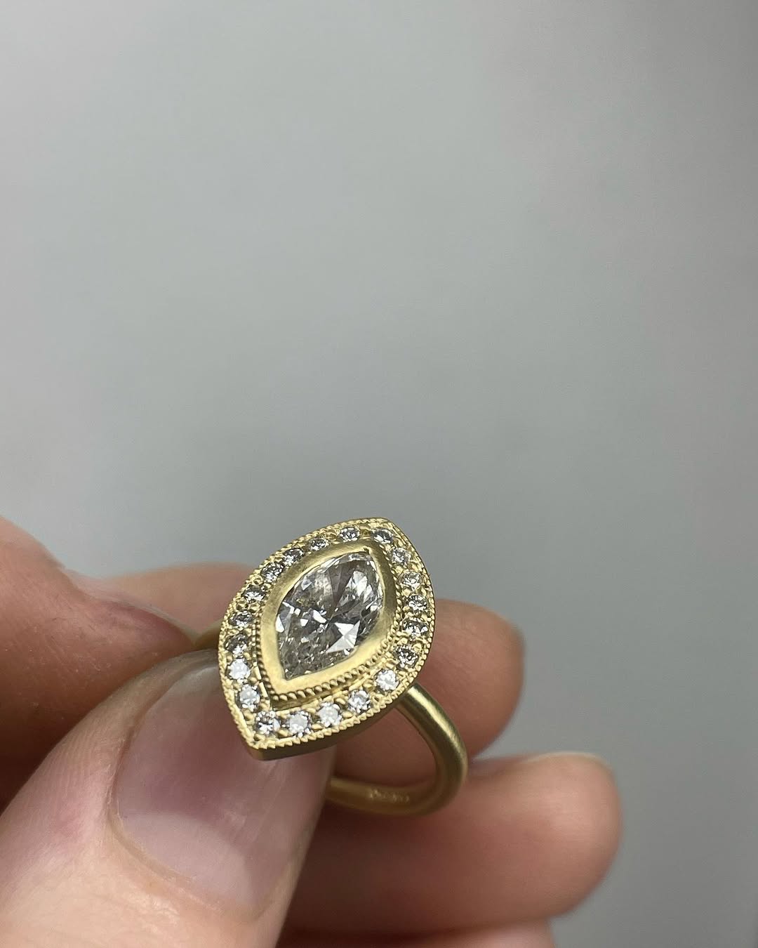 Front view of a vintage-inspired 3 CT marquise cut lab diamond ring held in hand